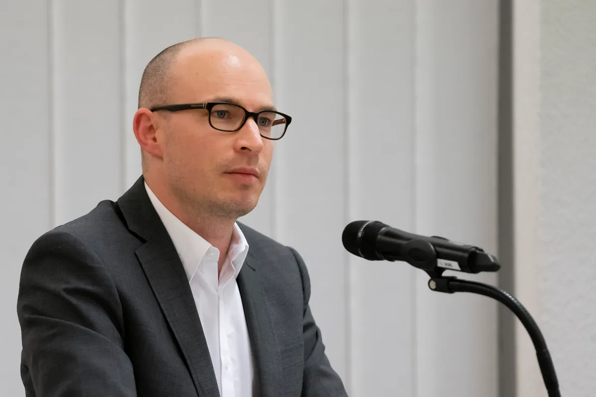 Nahaufnahme von einem Mann mit Mikrofon.